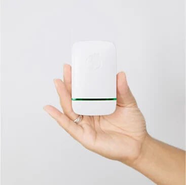 The unit held in an open palm to show its size