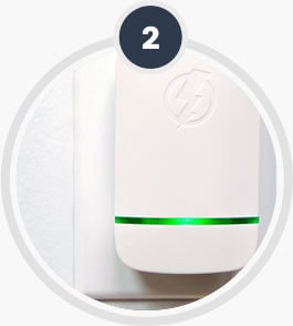 The unit seated in a wall outlet with its green band lit